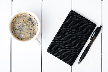 Image showing Smartphone with notebook and cup of strong coffee