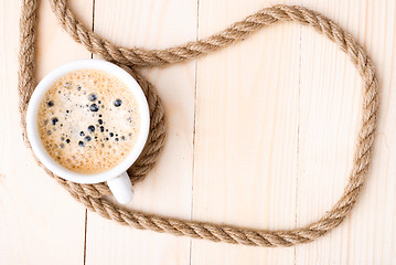 Image showing Cup of coffee with foam on wooden table