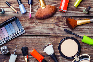 Image showing Make-up brushes and cosmetics on a wooden background