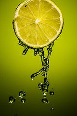 Image showing Drops of lime juice falling down. Colorful background