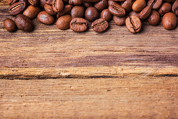 Image showing Black coffee beans on wooden table,