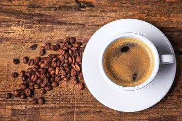 Image showing Coffee cup on a wooden table. Dark background.