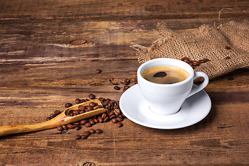 Image showing Coffee cup on a wooden table. Dark background.