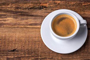 Image showing Coffee cup on a wooden table. Dark background.