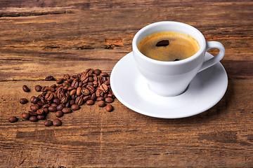 Image showing Coffee cup on a wooden table. Dark background.