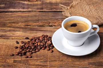 Image showing Coffee cup on a wooden table. Dark background.