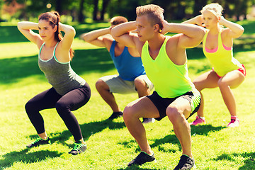 Image showing group of friends or sportsmen exercising outdoors