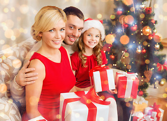 Image showing smiling family holding many gift boxes