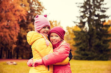 Image showing two happy little girls hugging in autumn park