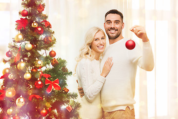 Image showing happy couple decorating christmas tree at home