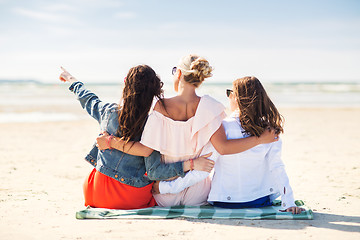 Image showing group of young women hugging on beach