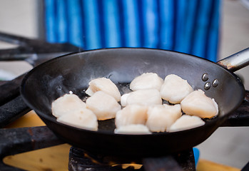 Image showing close up of scallops frying in cast iron pan