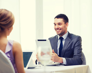 Image showing man with tablet pc looking at wife or girlfriend