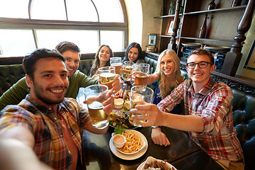 Image showing happy friends taking selfie at bar or pub