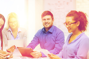 Image showing smiling team with table pc and papers working