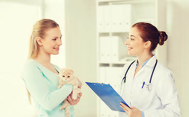 Image showing happy woman with cat and doctor at vet clinic