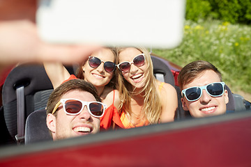 Image showing friends driving in cabriolet car and taking selfie