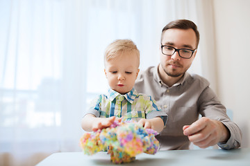 Image showing father and son playing with ball clay at home