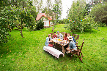 Image showing happy friends having dinner at summer garden party