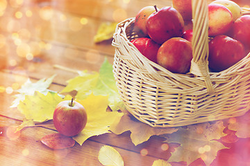 Image showing close up of basket with apples on wooden table