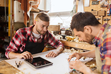 Image showing workmen with tablet pc and blueprint at workshop