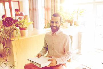 Image showing happy creative male office worker with folfer