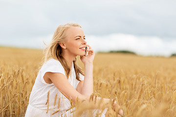 Image showing happy young woman calling on smartphone at country