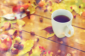 Image showing close up of tea cup on table with autumn leaves