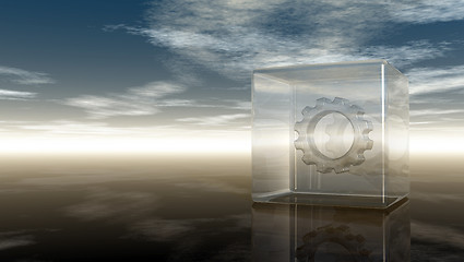 Image showing gear wheel in glass cube on reflective surface - 3d rendering