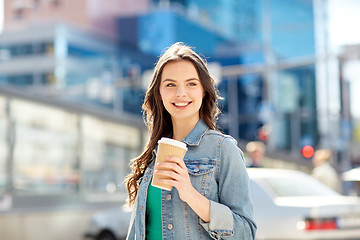 Image showing happy young woman drinking coffee on city street