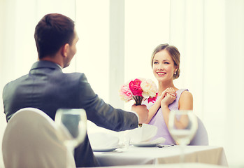 Image showing smiling woman recieving bouquet of flowers