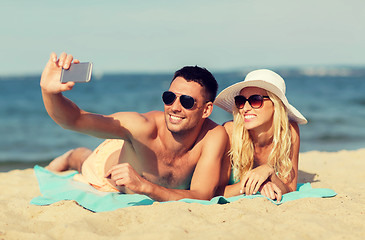 Image showing happy couple in swimwear walking on summer beach