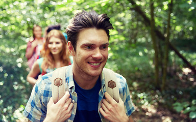 Image showing group of smiling friends with backpacks hiking