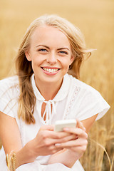 Image showing happy woman with smartphone and earphones