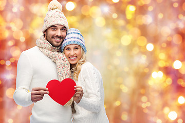 Image showing smiling couple in winter clothes with red hearts