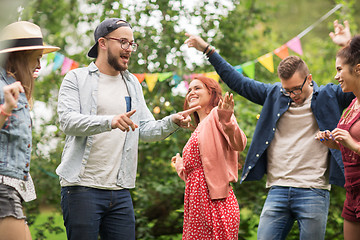 Image showing happy friends dancing at summer party in garden