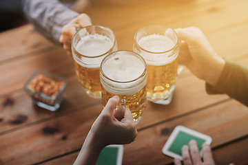 Image showing close up of hands with beer mugs at bar or pub