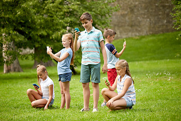 Image showing kids with smartphones playing game in summer park