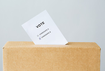 Image showing vote inserted into ballot box slot on election