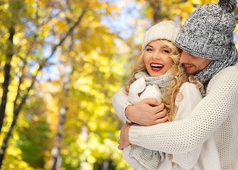 Image showing happy couple in warm clothes over autumn