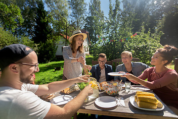 Image showing happy friends having dinner at summer garden party