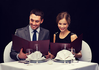 Image showing smiling couple with menus at restaurant