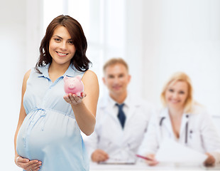 Image showing happy pregnant woman with piggybank