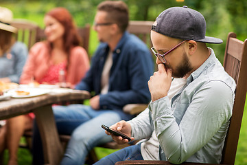 Image showing man with smartphone and friends at summer party