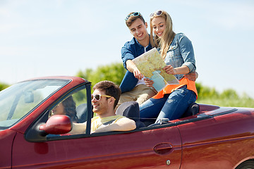 Image showing happy friends with map driving in cabriolet car