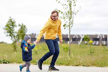 Image showing happy father and son with pinwheel toy outdoors