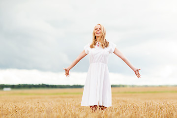 Image showing smiling young woman in white dress on cereal field