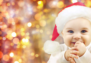 Image showing happy baby in santa hat over christmas lights