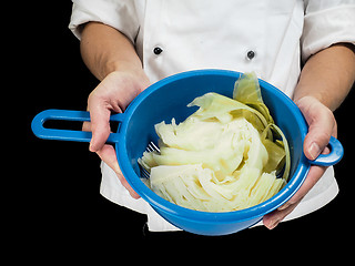 Image showing Freshly made boiled parted cabbage in a colander, held by chef i