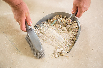 Image showing Worker Picking Up Pile of Debris on Cement